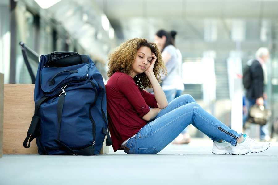 6 Not So Glamorous Facts about being a Digital Nomad - Woman sleeping at airport