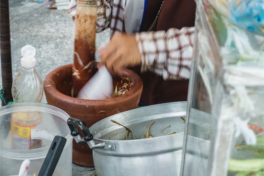 Street food vendor preparing papaya salad